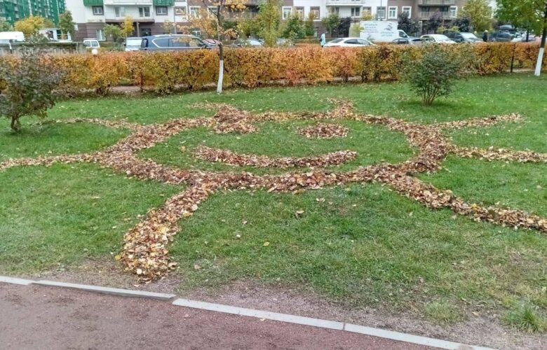 Дворник создал солнце на газоне из опавших листьев на бульваре Менделеева